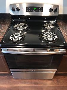 Brand new stainless steel and black stove with over head fan